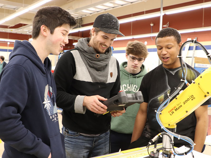 Students stand around a robotics instructor at the CCAC Makerspace