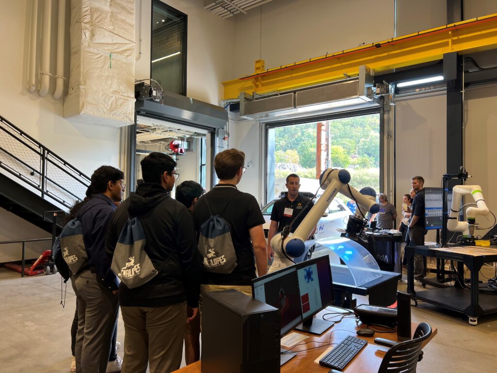 Students gather around a robotics demo at Mill 19