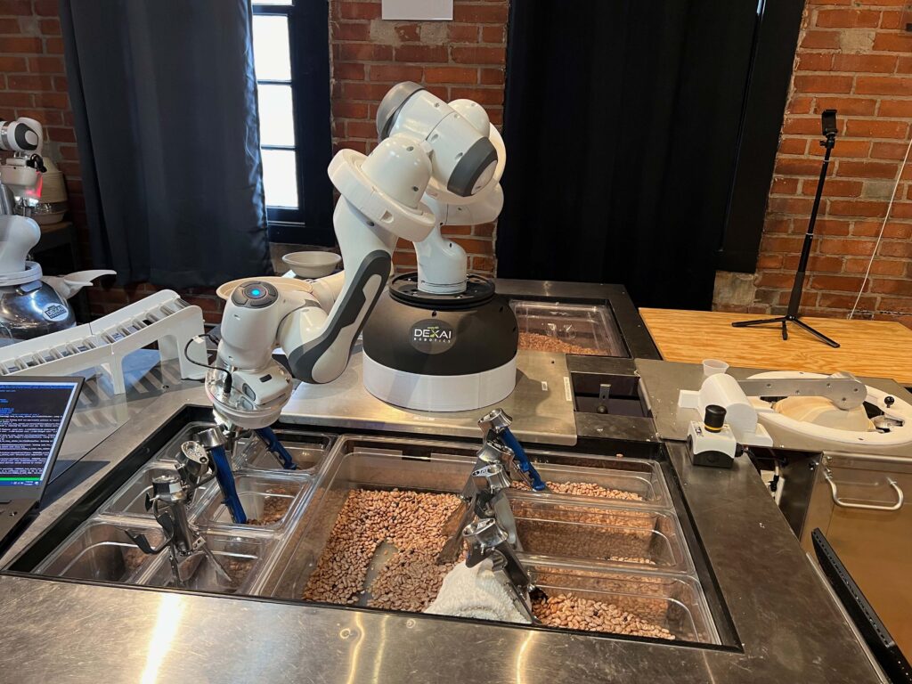 The robot scoops ingredients during the final demo