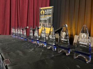 A photo showing ARM Champion awards in a line on a table