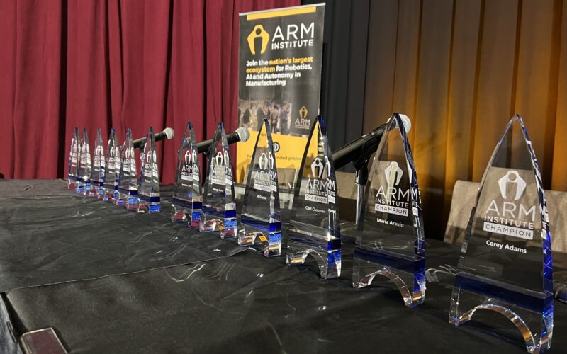 A photo showing ARM Champion awards in a line on a table