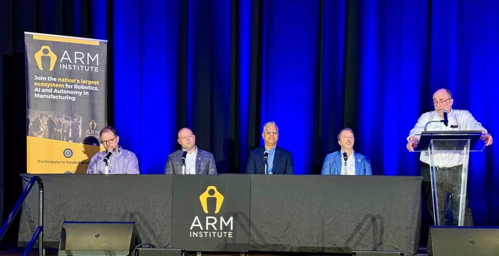 Individuals seated at a table for a panel discussion