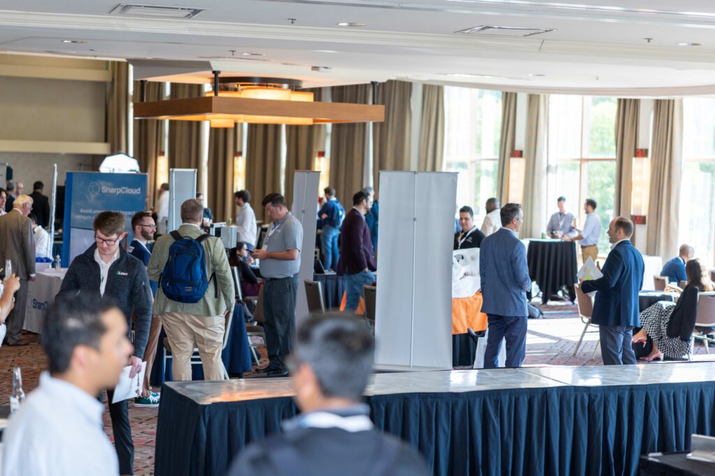 People walk through tables in the Member Showcase Hall