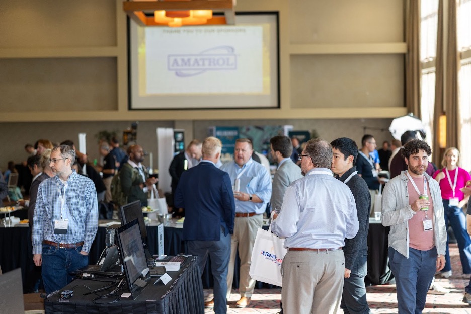 People walk through a reception area filled with exhibit tables