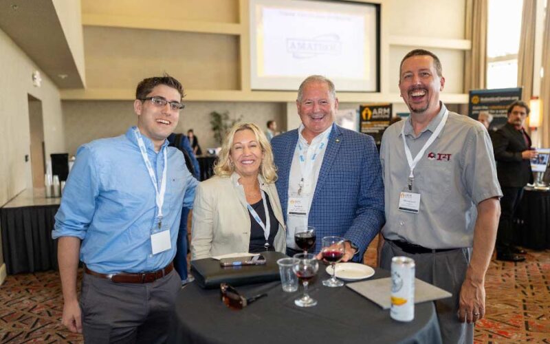 Three people take a photo together at the Member Meeting
