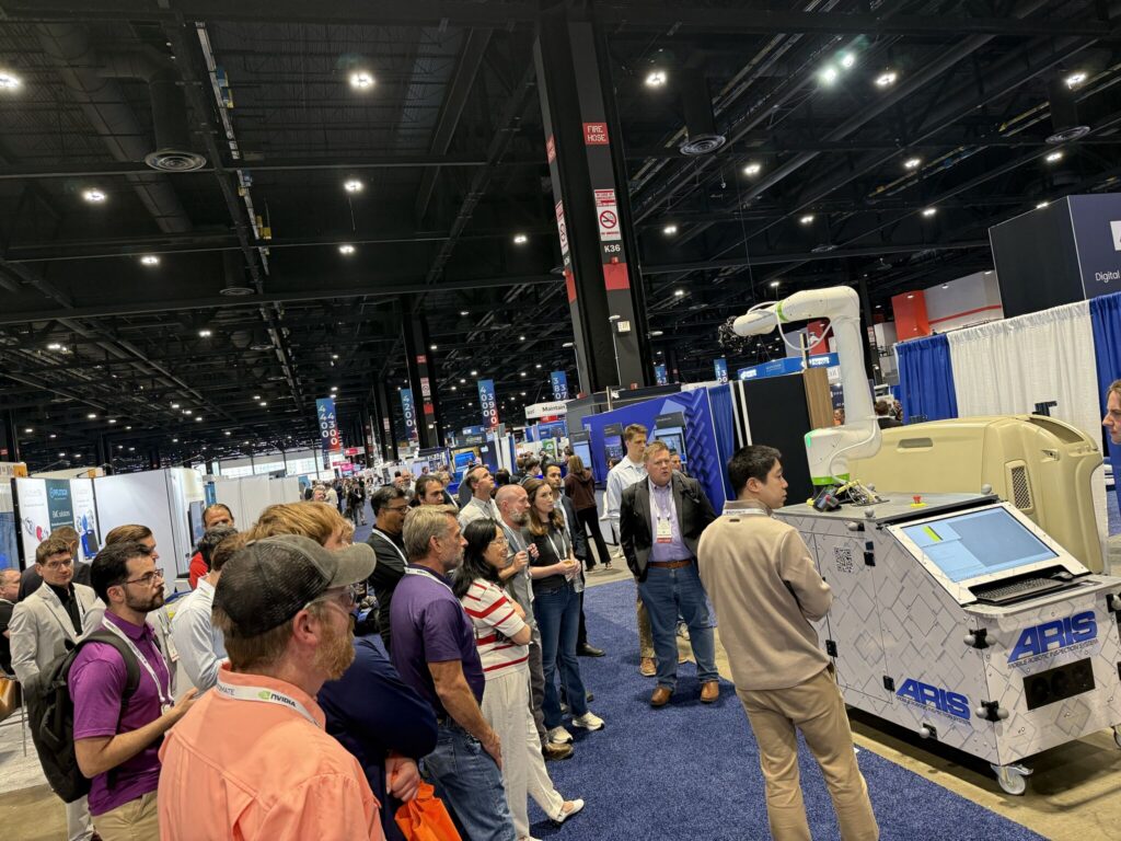People gather around a robot at a tradeshow
