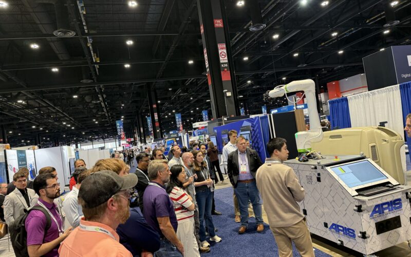 People gather around a robot at a tradeshow